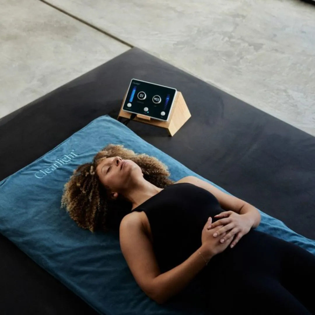 Clearlight Amethyst Infrared PEMF Mat being used by a woman.